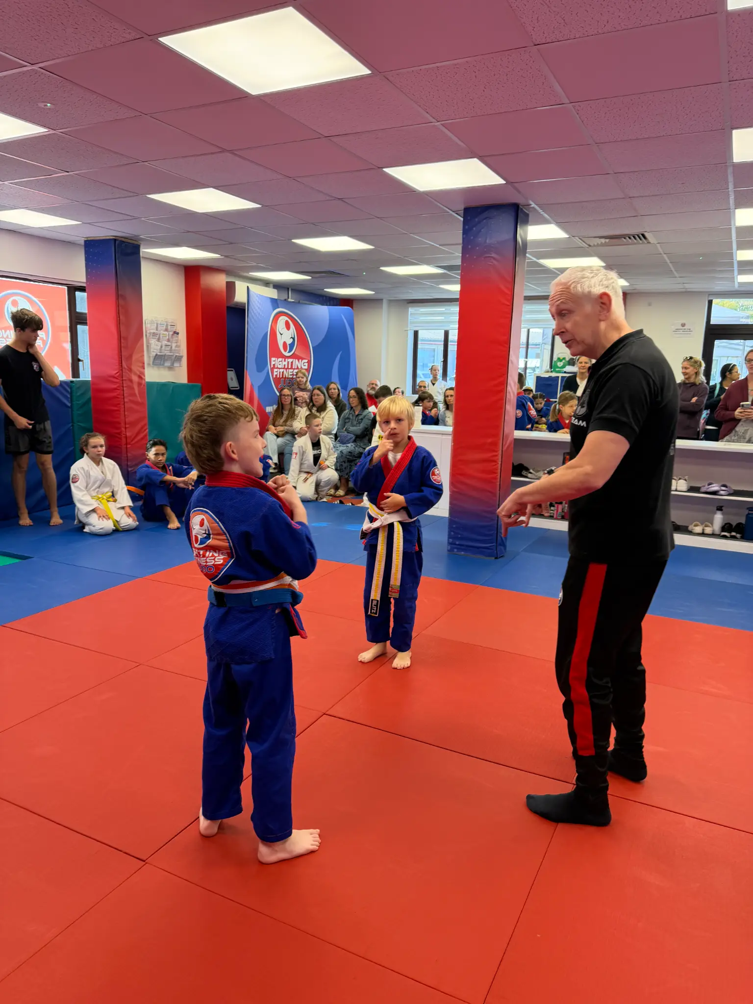 A young judoka receiving encouragement from a coach