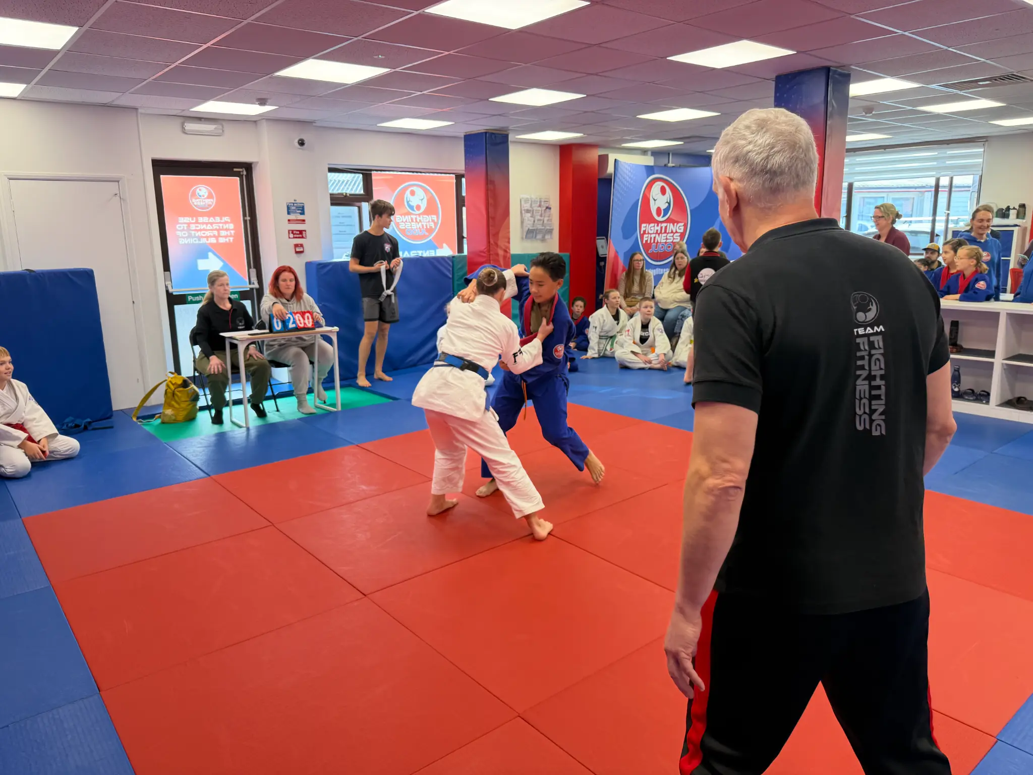 Young judoka competing in front of cheering families