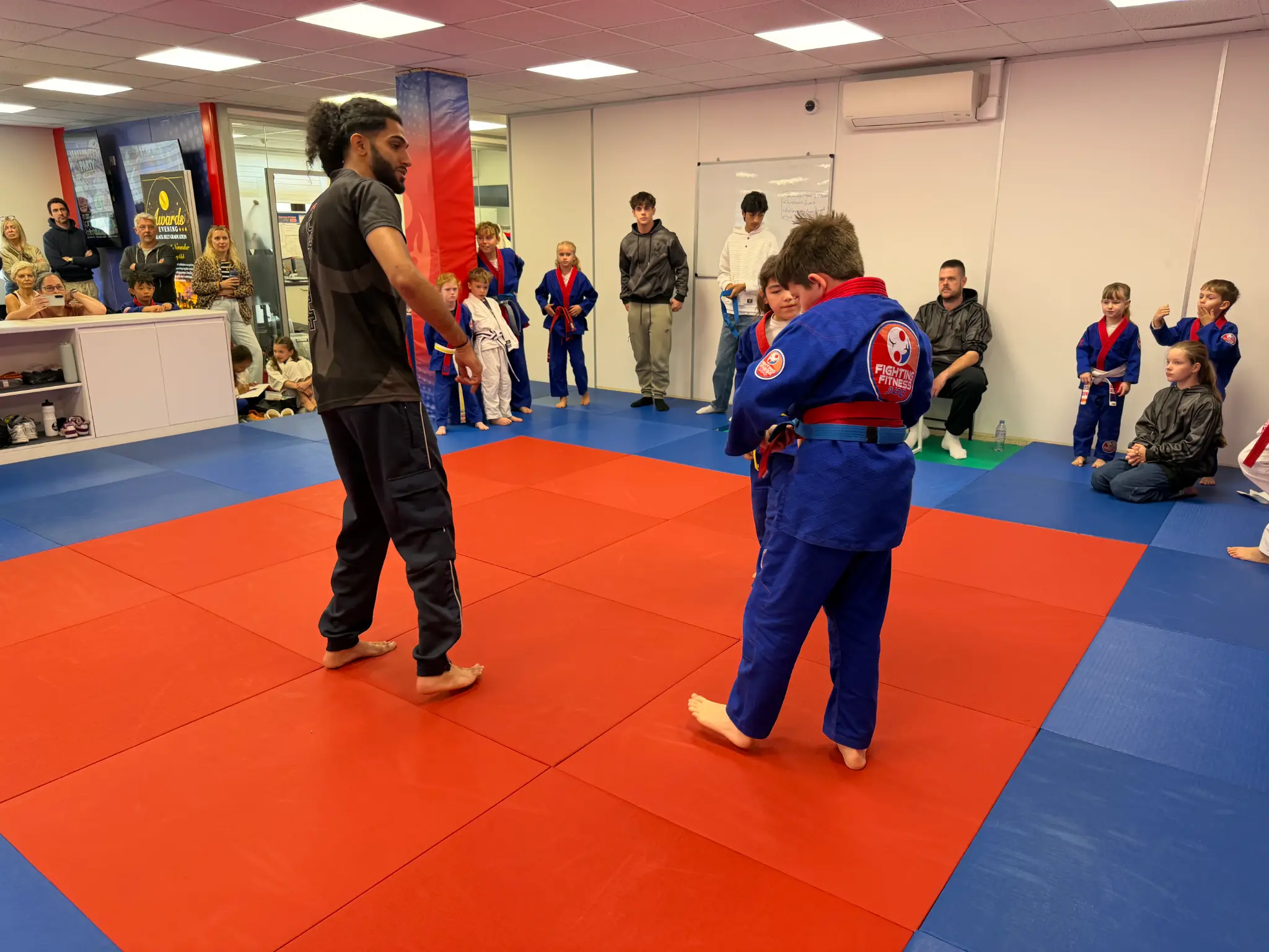 A coach supporting young judoka between Team Festival battles