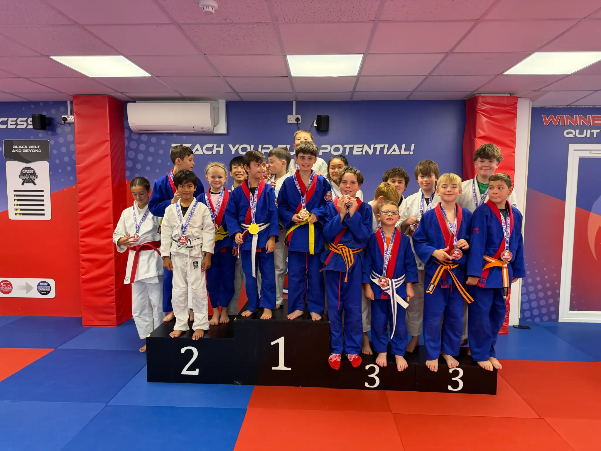 Fighting Fitness Judo members celebrating together with Team Festival medals